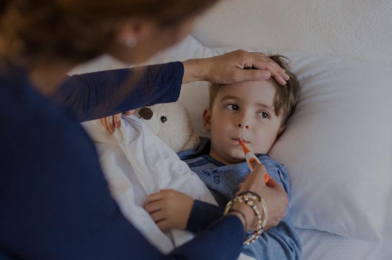 Fievre chez l enfant Mère qui prend la température de son enfant dans le lit