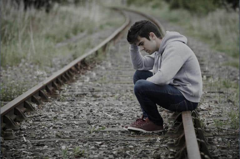 suicides idees noires Jeune homme en dépression au milieu d'un chemin de fer