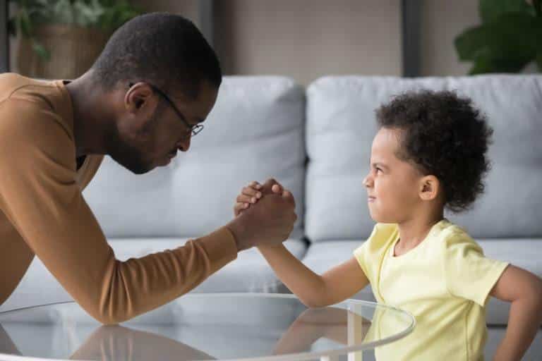 parents-vacances-enfants Enfant faisant un bras de fer avec un homme adulte
